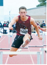 Tanner McDonald clears a hurdle on his way to an eighth-place finish in the 300-meter hurdles with a time of 41.15 seconds at the NDHSAA Class B State Track and Field Meet. Photo by Larry Stokke