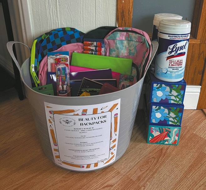 The Honeycomb Hair Salon’s “Beauty for Backpacks” donation bin is filling with supplies for area schools. Throughout August, the salon will donate one school supply for every service booked. Submitted photo.
