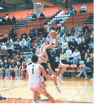 Kaden Moore gets some air while eyeing the basket for two points. Photo by Ashley Schafer