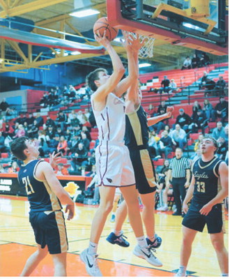 TJ Henderson puts up a shot under pressure at the basket. Photo by Larry Stokke