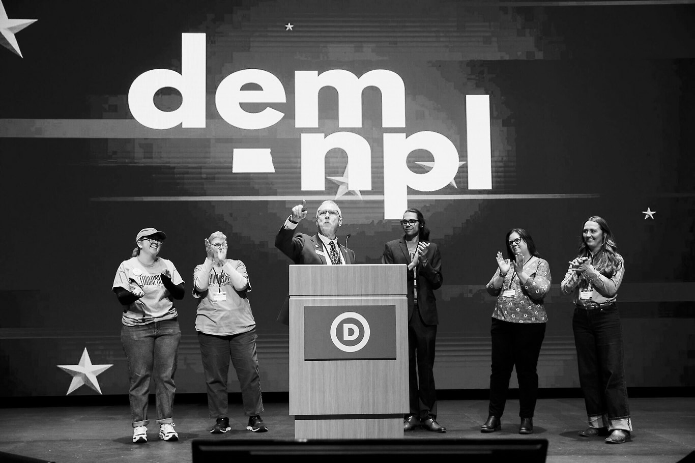 Vern Thompson, center, a former Dem-NPL state lawmaker, speaks during the Dem-NPL state convention in Bismarck on March 7, 2026. Thompson failed to secure the party's endorsement for U.S. House but announced Friday he's running for state agriculture commissioner. (Photo by Kyle Martin/For the North Dakota Monitor)