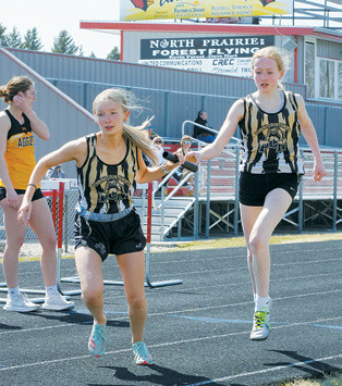 Charlotte Crowston hands off the baton to Emersen Helgoe. Along with teammates Delaney Denault and Maci Puppe, the girls PCN 4X800 relay team took home 1st place. Photo by Larry Stokke.