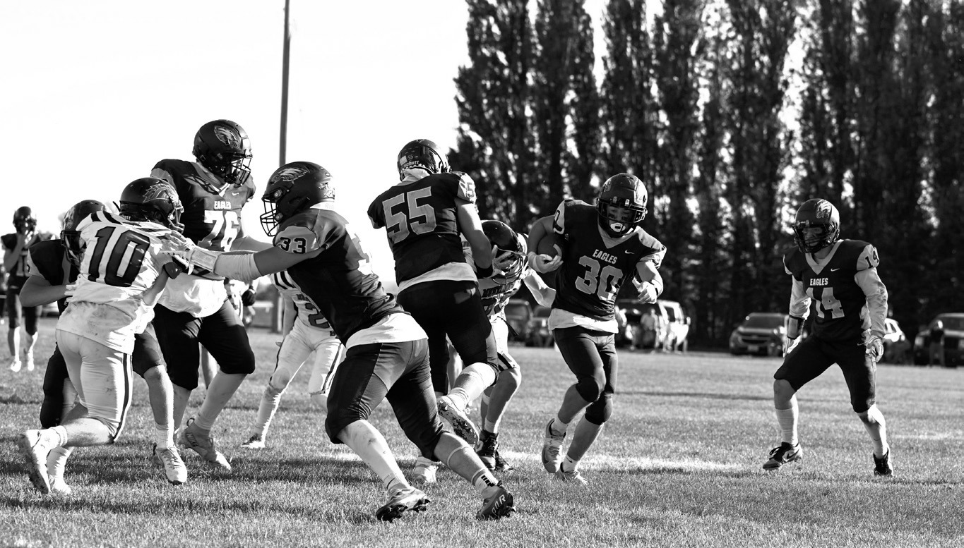 Kade Schafer, Gavin Symington and Colton Bailly hold off the defense so Brody Berg can gain the yards. Photo by Ashley Schafer.