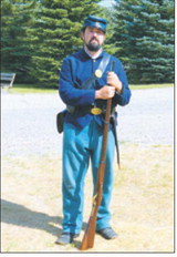 Brian Hardy portrays a Civil War soldier, holding a period rifle during the Living History Day on Aug. 16. Photo by Larry Stokke