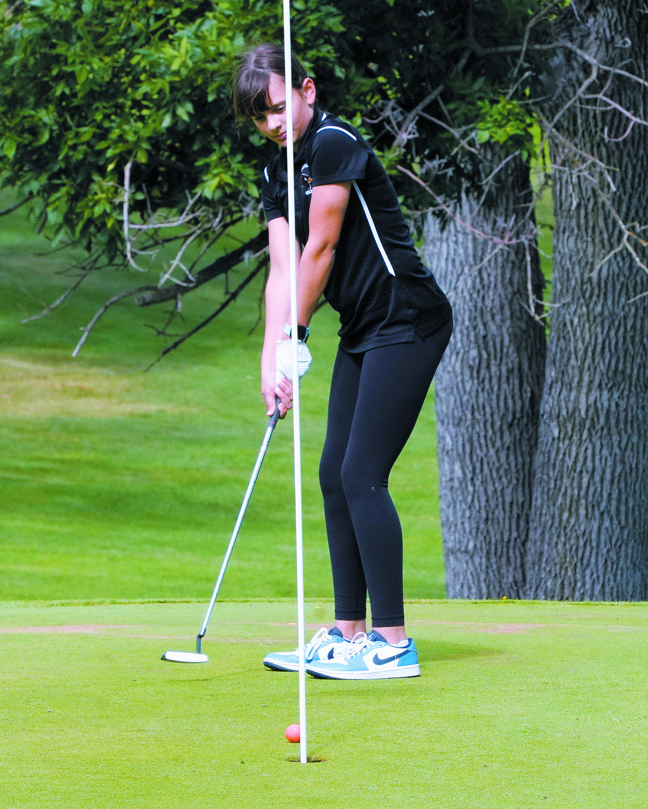 Lily Zimmer sinks a putt and placed 7th in the meet. Photo by Larry Stokke