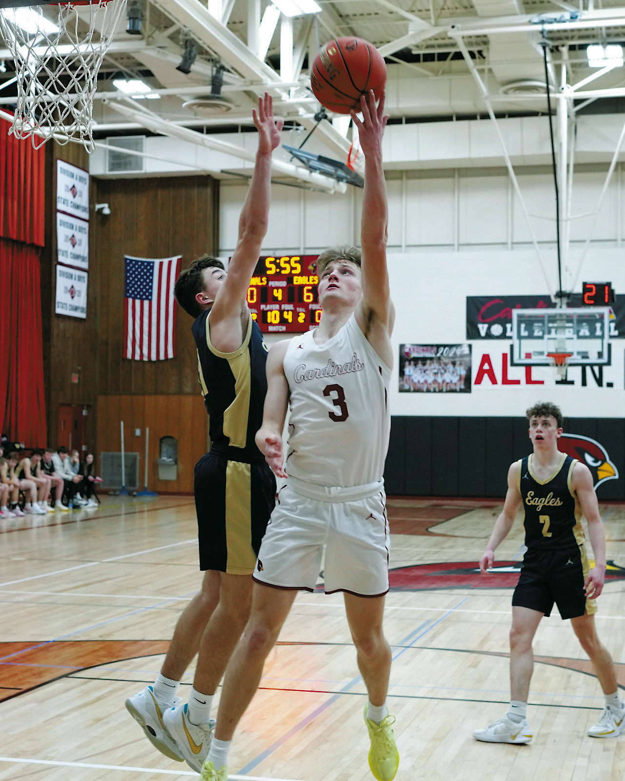 Cody Amble drops in a basket over Brody Berg's outstretched hand. Photo by Larry Stokke.