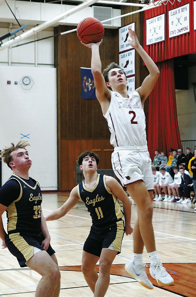 Tanner McDonald drives the lane and drops in a bucket against the North Border Eagles. Photo by Larry Stokke.