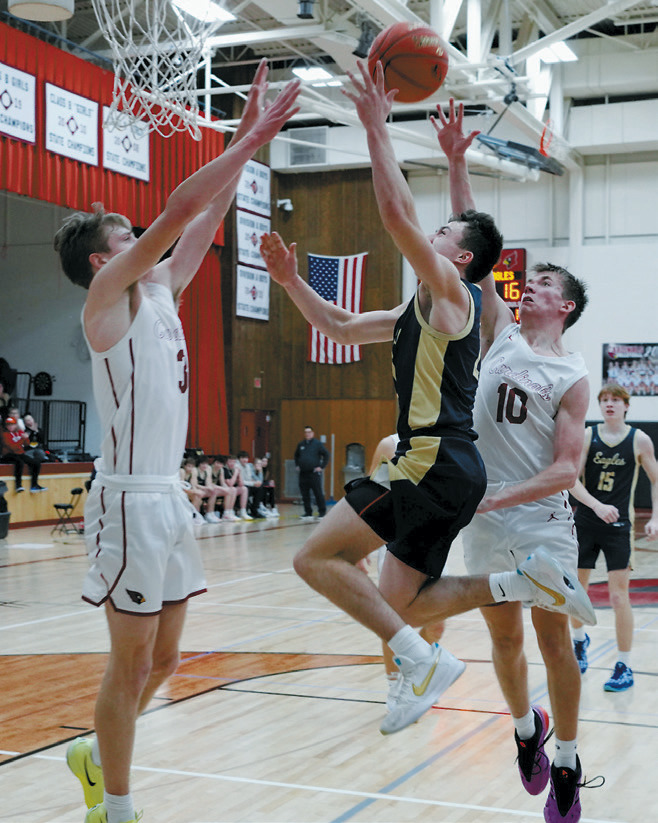 Brody Berg drops in a basket over Cody Amble in the Eagles' win over the Cardinals. Photo by Larry Stokke.
