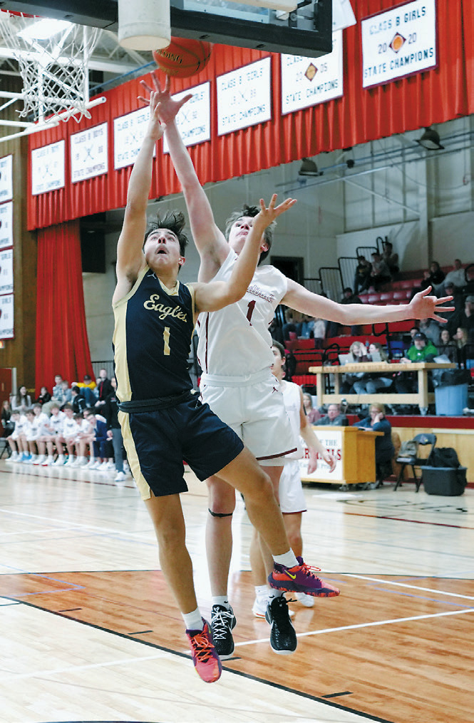 Weston Cosley goes up for a basket with Eastyn Schaefer right behind him trying to contest the shot. Photo by Larry Stokke.