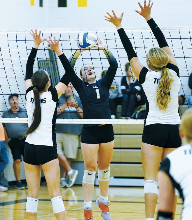 Hannah Moore sets the ball between two blockers during the Northern Cass Tournament on Aug. 29. Photo by Larry Stokke