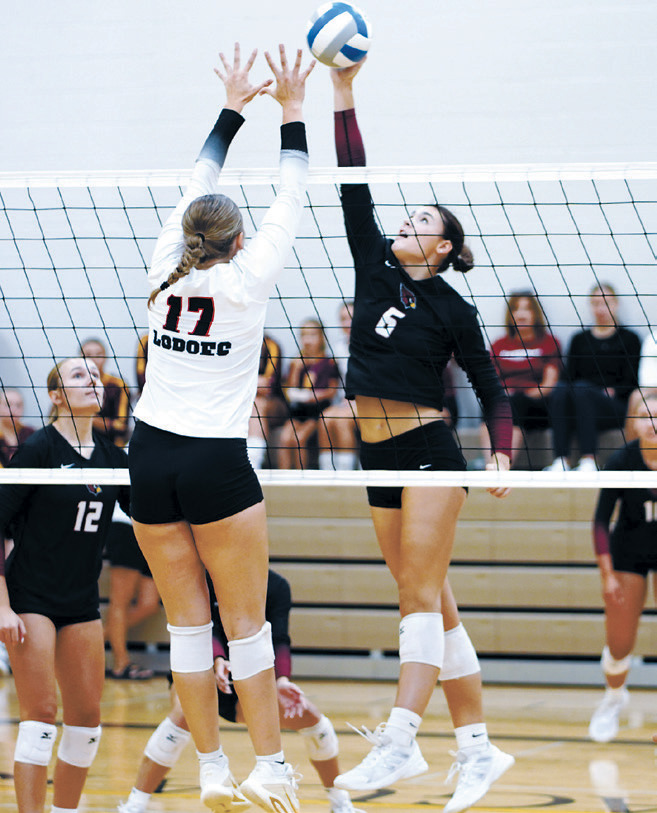 Taya Feist uses a tip attack against the opposing block. Photo by Larry Stokke