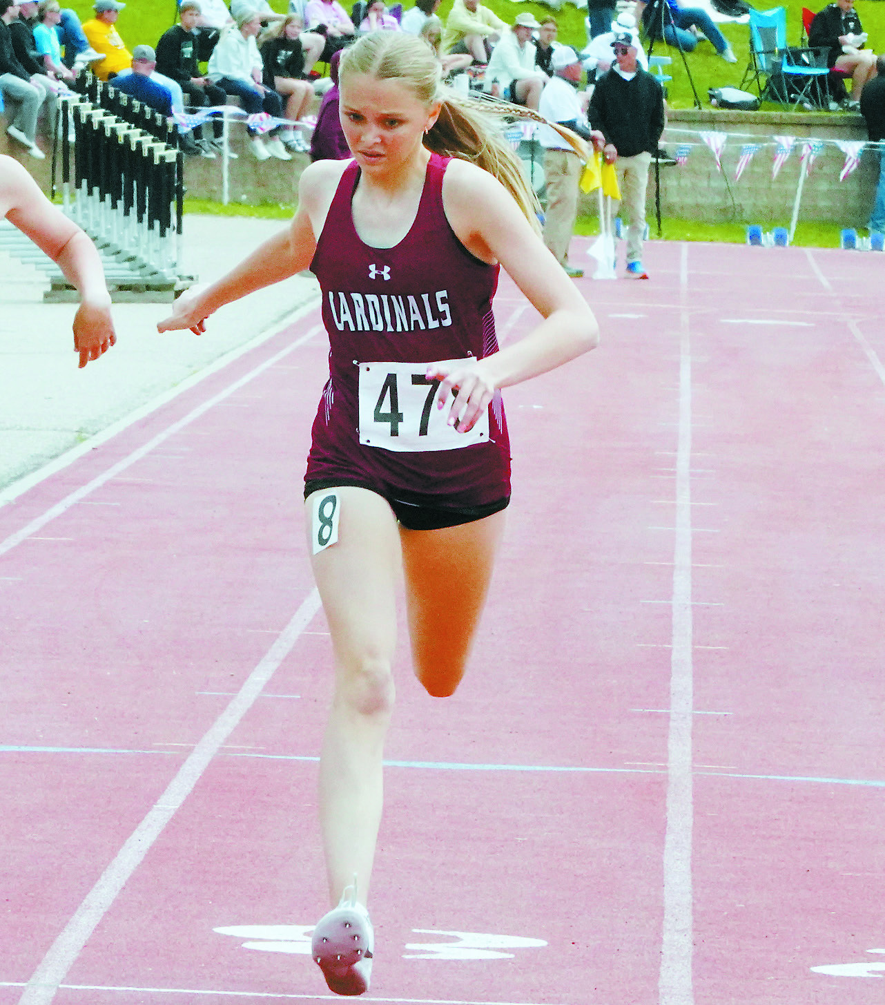 Hallie Overby crosses the finish line in the 400 meter run. Photo by Larry Stokke.