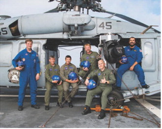 Chris Johnson, standing center, poses with members of the Artemis I recovery team aboard a U.S. Navy vessel following the successful splashdown and recovery of the Orion spacecraft in 2022. Johnson served as part of the Air Operations team during the mission. Photo courtesy of NASA