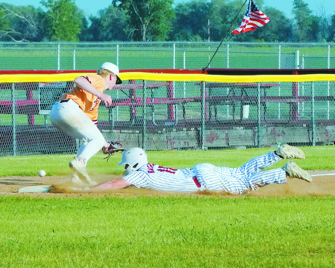 Jax Johnson connects for a base hit in the Cardinals' win over Grafton on June 16. Cody Amble dives safely headfirst onto third base. Photo by Larry Stokke. Photo by Larry Stokke.