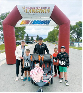Family affair – The Roy family poses beneath the Run Langdon finish arch following the June 13 event in Langdon. Family members participated in the race while the youngest member enjoyed the festivities from a stroller. Submitted photo