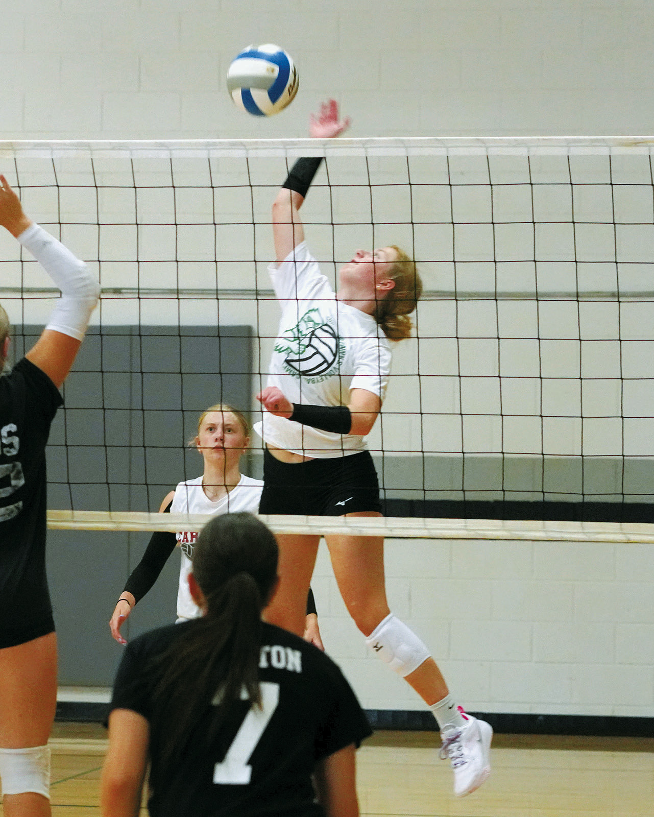 Claire Chaput sends the ball back over the net against the Hatton-Northwood team on July 22. Photo by Larry Stokke.
