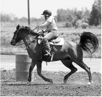 Maggie Iverson races to a first-place finish in the barrel race during the Sapa Arena Fun Day on June 7. Photo by Larry Stokke