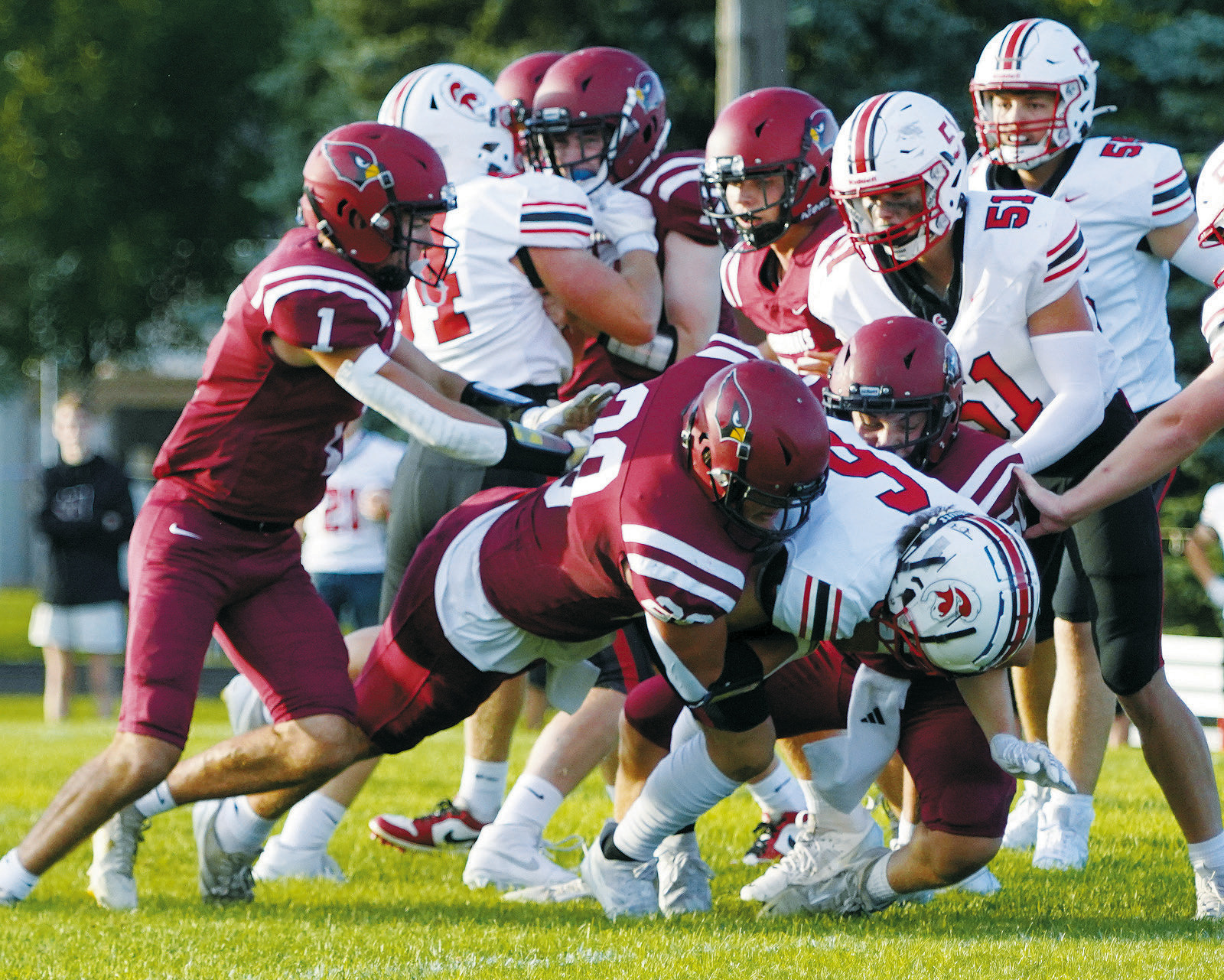 Theo Romfo and Landon Schneider tackle running back Ayden Thummel. Photo by Larry Stokke.