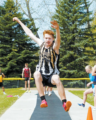 Garrett Willits competing in long jump. Photo by Larry Stokke.