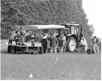 Visitors tour research plots aboard a wagon during the Langdon Research Extension Center Field Day on July 16. The annual event featured updates on crop research, disease management, soil health and varietal trials, along with a stop at the site of the new seed cleaning facility. Photo by Larry Stokke