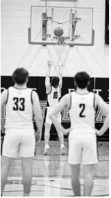 Teammates watch as Colton Bailly puts up a free throw. Photo by Ashley Schafer