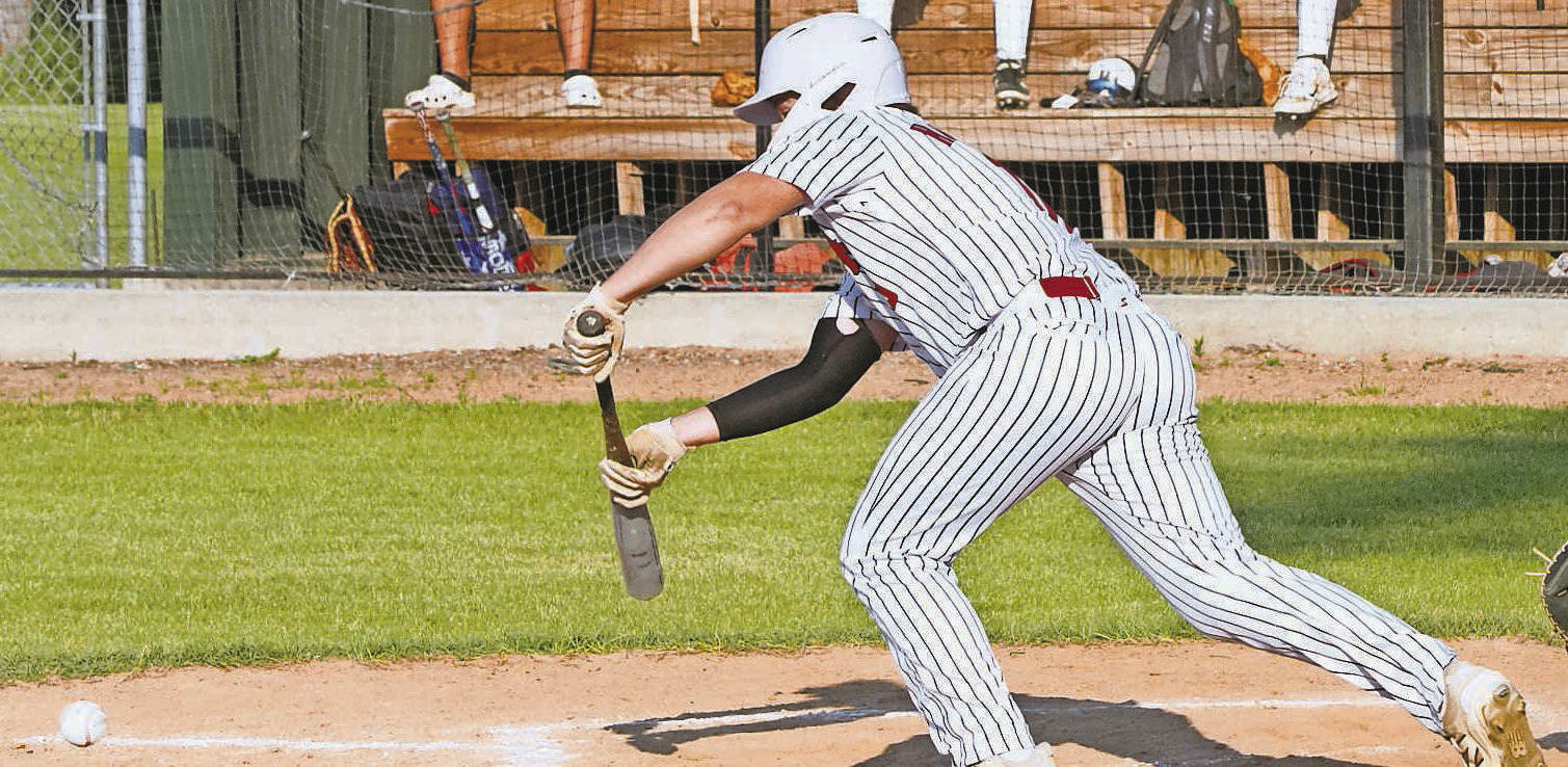 Devin Hakanson bunts the ball, bringing in a run and helping the Red Sox beat Midway/Minto. PHOTO BY LARRY STOKKE.