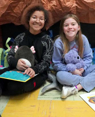 Two students read with their stuffed animals at Munich School.