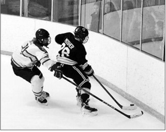 Carter Mosher gains control of the puck along the glass with the faithful Langdon fans on the other side cheering him on. Photo by Larry Stokke