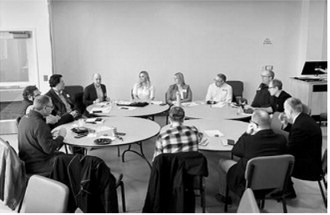 Participants discuss current and future issues impacting agriculture and rural communities at a roundtable held by North Dakota News Cooperative with PolicyLink representative Josh Kirchenbaum, seated to right of Sabrina Halvorson (NDNC CEO, in orange). Photo Rusty Halvorson.