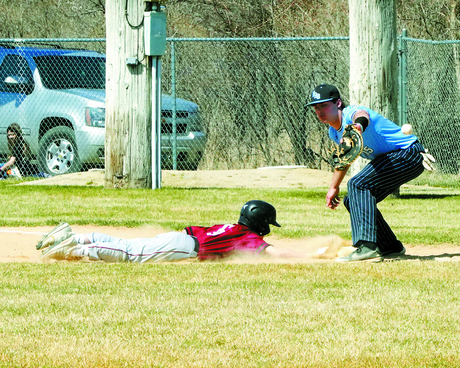 Connor Mitchell slides safely back to the base, barely beating the ball. Photo by Larry Stokke.