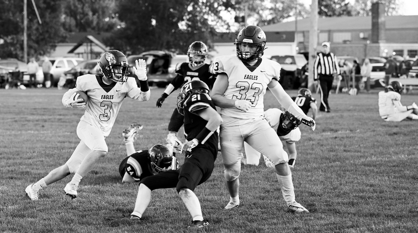 Kade Schafer clears the path as Oakley Brown fights for extra yards on the carry.