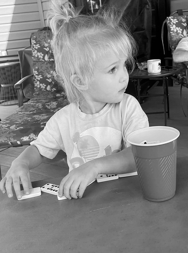 A rare photo of Bob Simmons RELAXING. Little Rosie having fun with dominos at the lake.