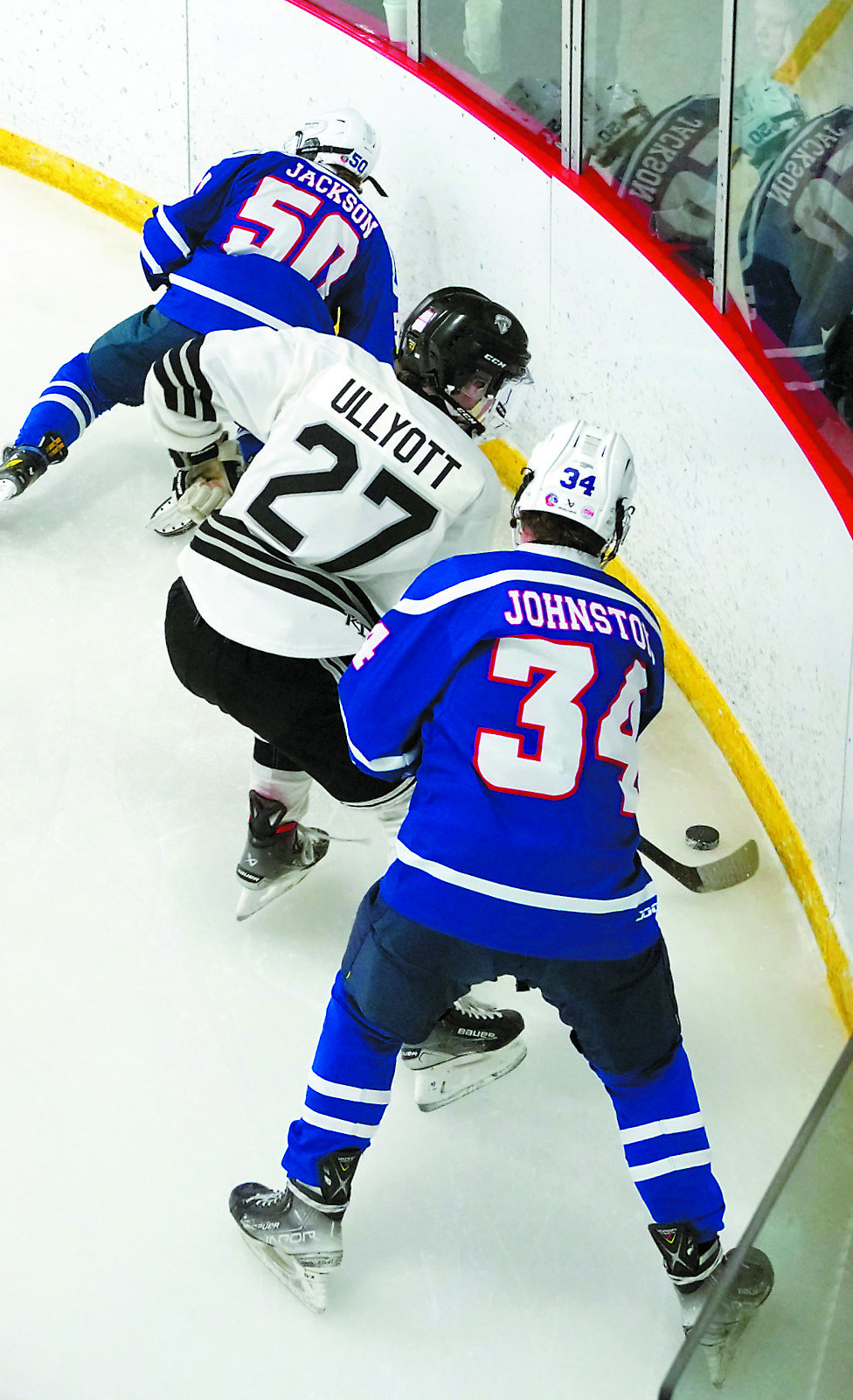 Keaton Ullyott fights for control of the puck along the boards against Richland on Feb. 1 at the Dakota Spirit Arena. Photo by Larry Stokke.