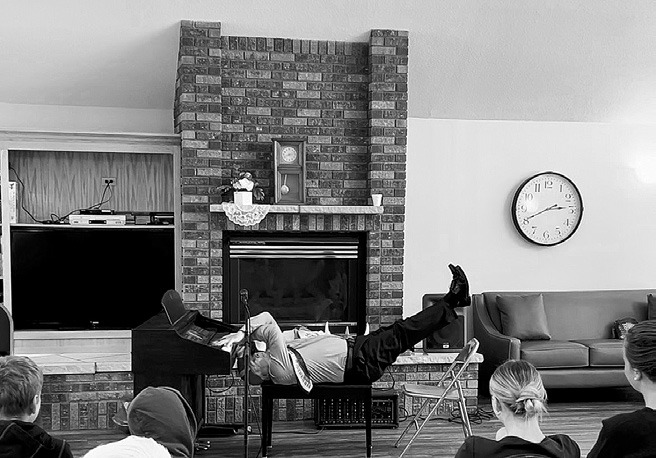 Gordy “Crazy Fingers” Lindquist laying down, while playing the piano upside down.