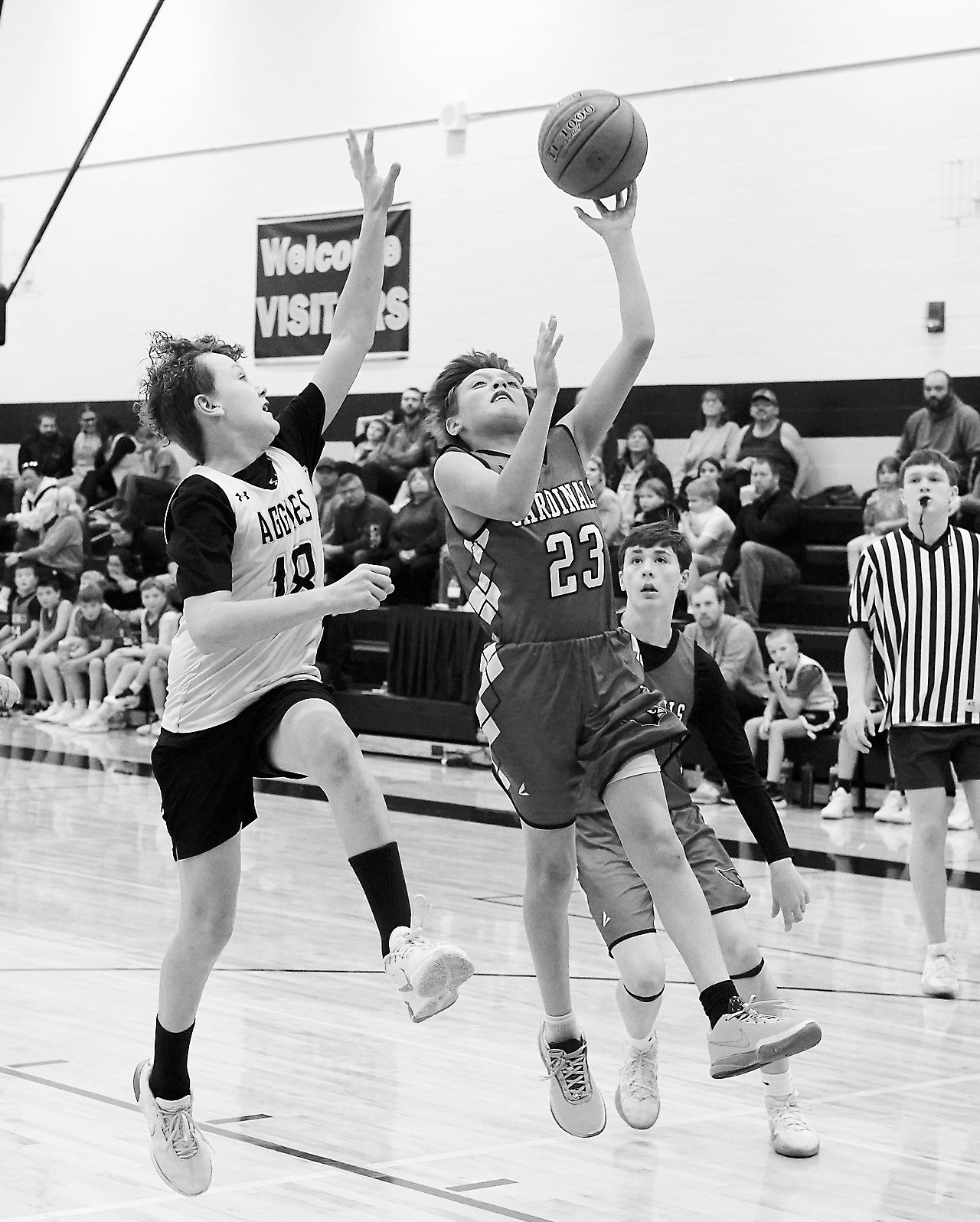 Kaden McKay drops in a left handed lay-up against the Aggies. Photo by Larry Stokke.