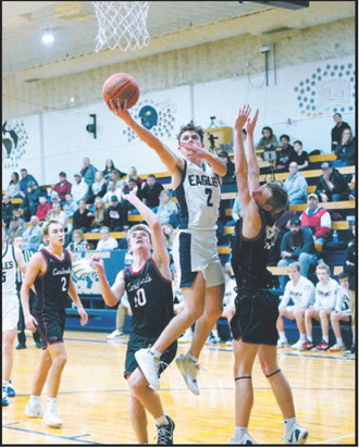 Kaden Moore drives to the basket and drops in a right-handed shot finishing the game with 13 points. Photo by Larry Stokke.