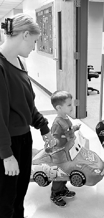 Jamestown high school student Larkin Kleven escorts Eddie Ranum in his ‘Cars’ costume at the Little Blue Jays Nest as she works toward credit for her Child Development Associate certification. Photo provided by Teresa Olson.