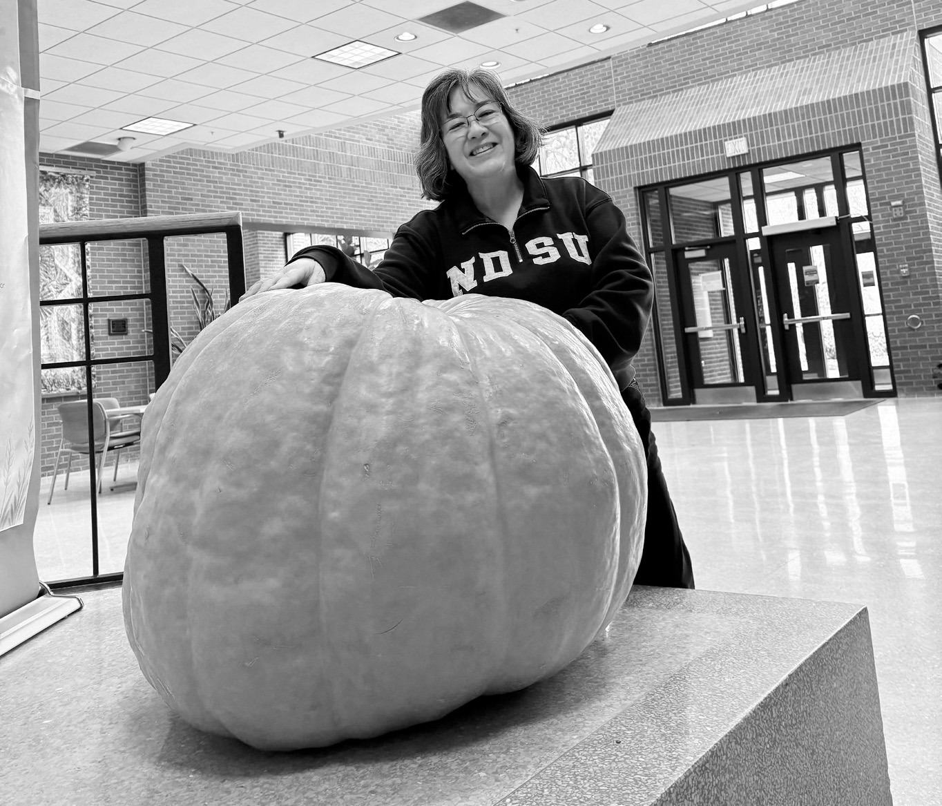 Esther McGinnis, NDSU Extension horticulturist, stands next to a giant pumpkin on the NDSU campus, and shares some little-known facts about pumpkin in this week's Dakota Gardener. (NDSU photo)