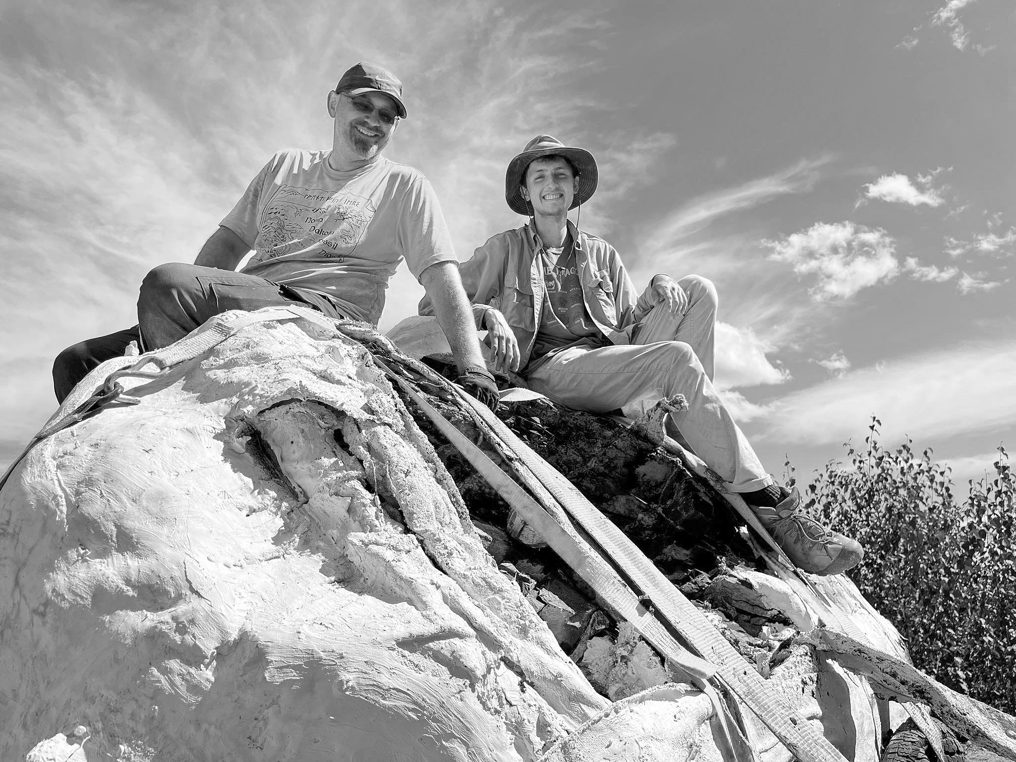 Paleontologist Clint Boyd (left) with intern Kale Link (right) as they sit atop the freshly flipped fossil fish, Jimmothy the Ichthyodectes. Photo courtesy of N.D. Geological Survey.