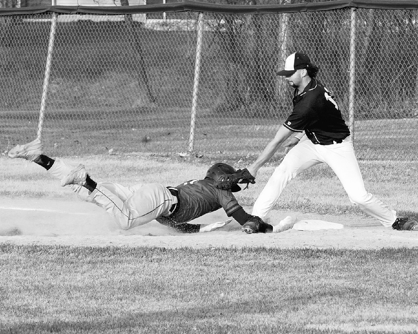 Kadyn Hein dives back safely to first base against Park River. Photo by Larry Stokke.