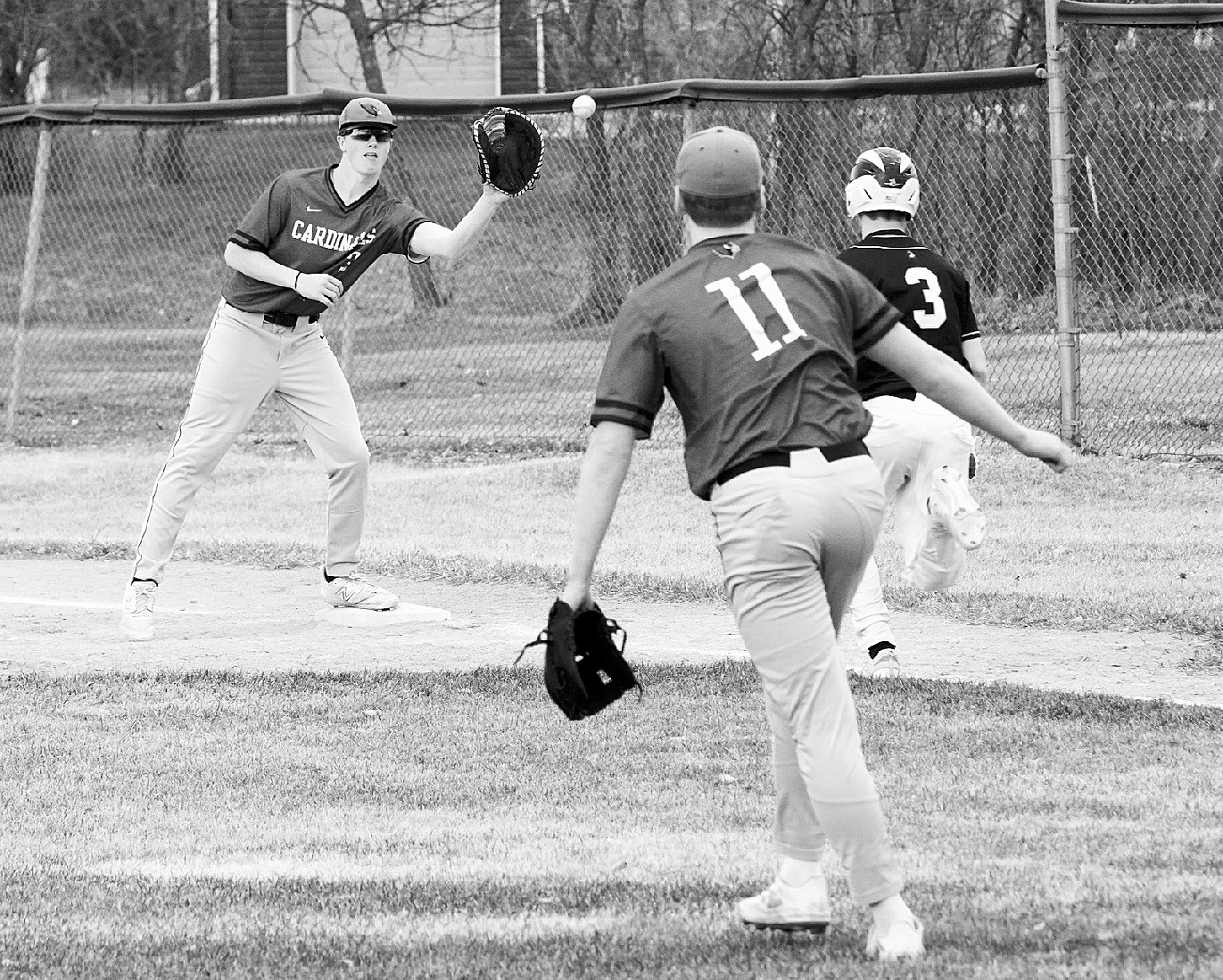 Dawson Hein gets a throw from Jax Johnson to put out the Park River player. Photo by Larry Stokke.