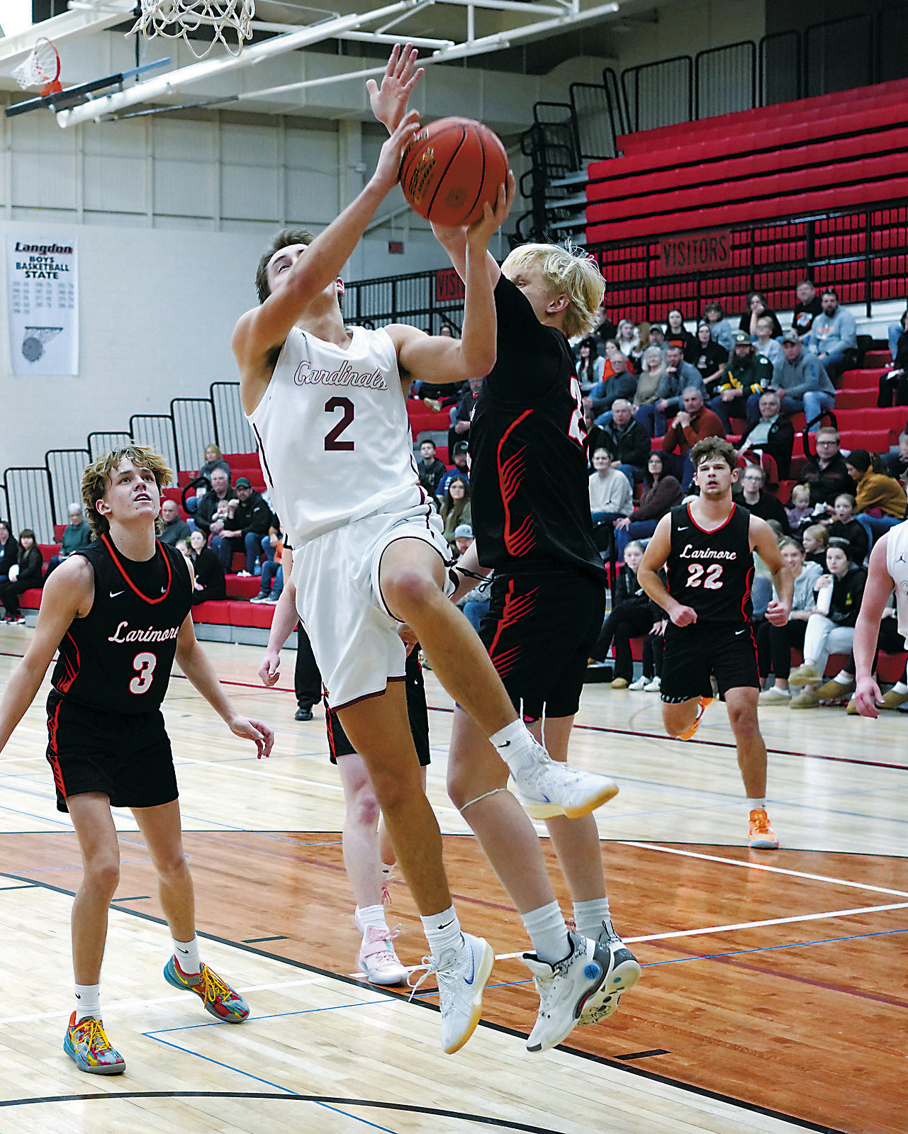 Tanner McDonald drives in and drops a layup in the Cards game with Larimore in Langdon on Jan 10. Photo by Larry Stokke.