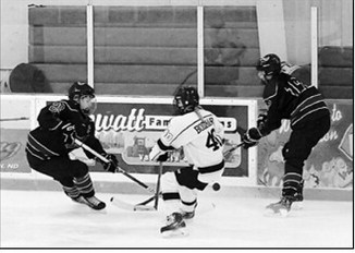 Remmi Bodnar tangles with two Bottineau players for control of the puck. Photo by Larry Stokke