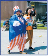 Parade participants make their way down the street during Pembina's Fourth of July parade, tossing candy and spreading patriotic spirit as community members gathered to celebrate Independence Day. Photo by Larry Stokke