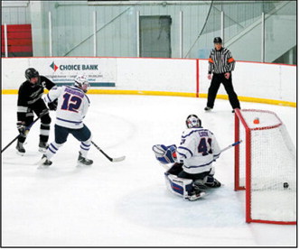 Jax Johnson fires a shot past a Richland defender and the goalie with an assist from Max Henderson for one of his two goals in the Blades win over Richland. Photo by Larry Stokke..