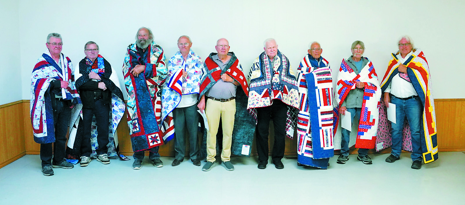 Quilts of Valor recipients (L-R) Fred Domres, Emeric Boesl, David Chaput, Rick Crockett, Richard Rose, Francis Hoffarth, Dennis Metzger, Terry Howatt, and Robert Becker. Photo by Larry Stokke.