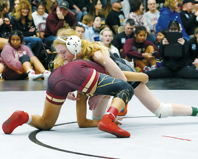 Charlotte Crowston in the 112 lb weight class gains some points taking her opponent to the mat in Grand Forks on Saturday, Dec. 14. Photo by Larry Stokke.