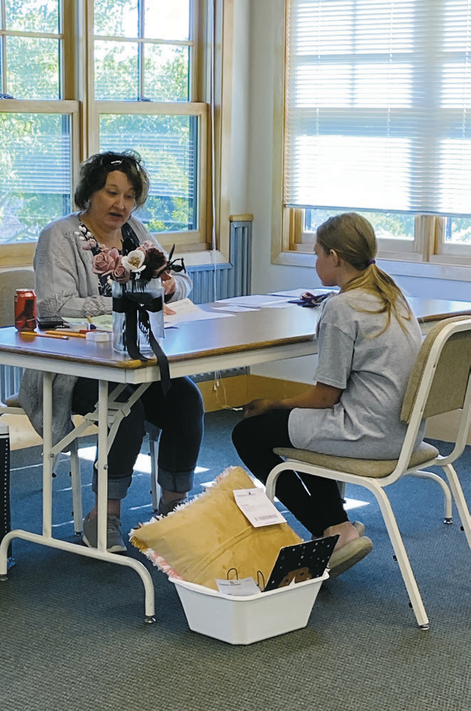 Amy Kram visits with a Cavalier County 4-H member during interview-style judging at 4-H Achievement Day on June 16 at the Langdon Research Extension Center.