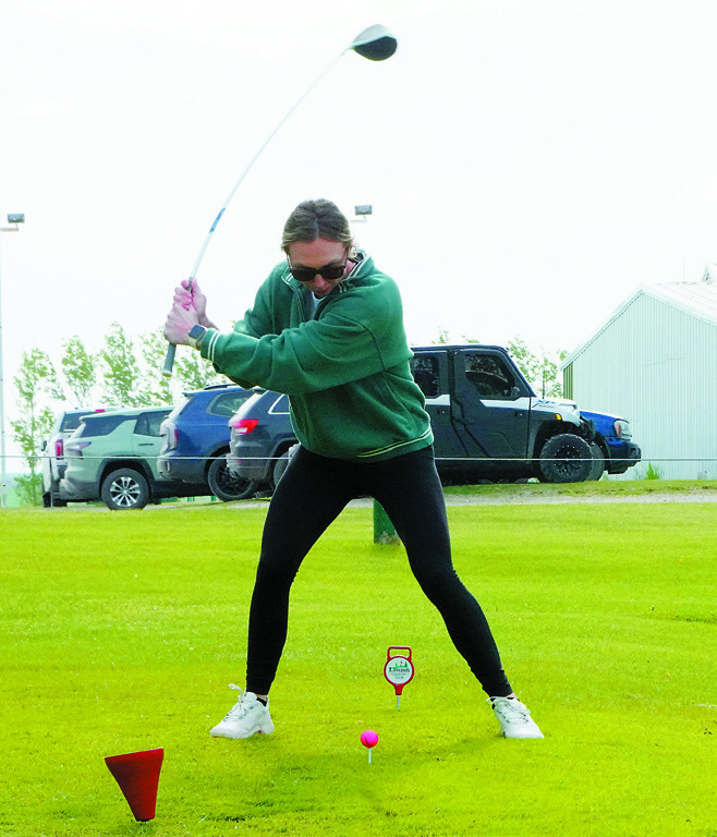 Mackenzie Rindy puts a little bend in her club as she tee's off at the LPH Foundation Golf Tournament on June 7 in Langdon. Photo by Larry Stokke.