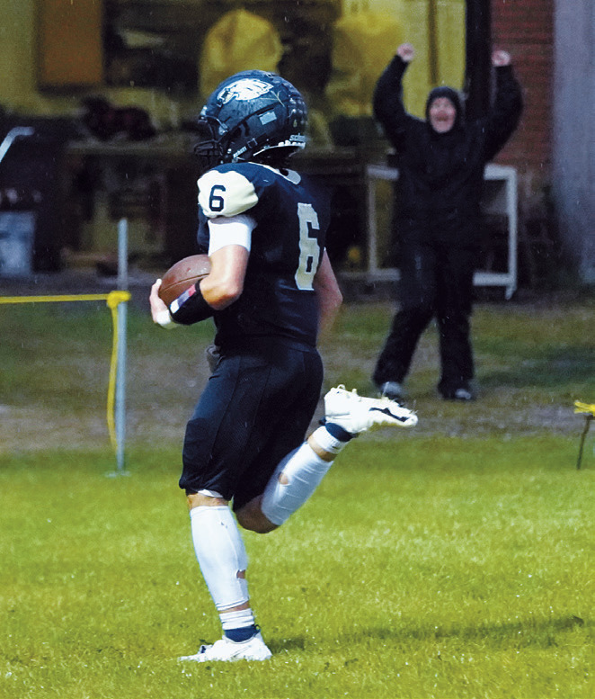 Grant Cosley runs in one of his five touch downs in front of a North Border fan. Photo by Larry Stokke.